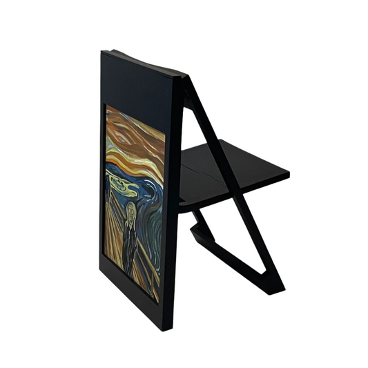 The PicChair in Black open as a chair; Viewed with painting of The Scream in the picture frame.