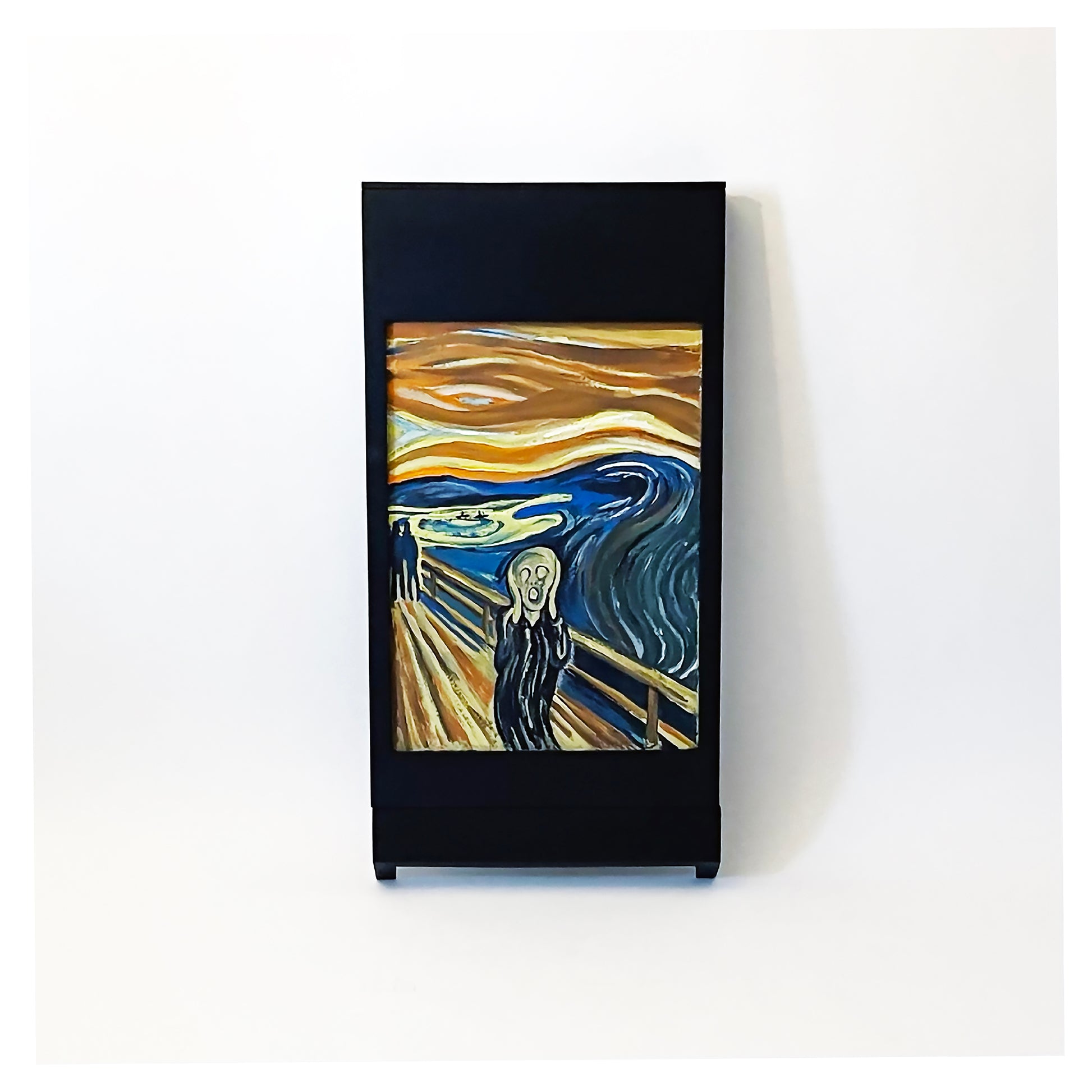 The PicChair in Black hanging on a wall  with painting of The Scream in the picture frame.