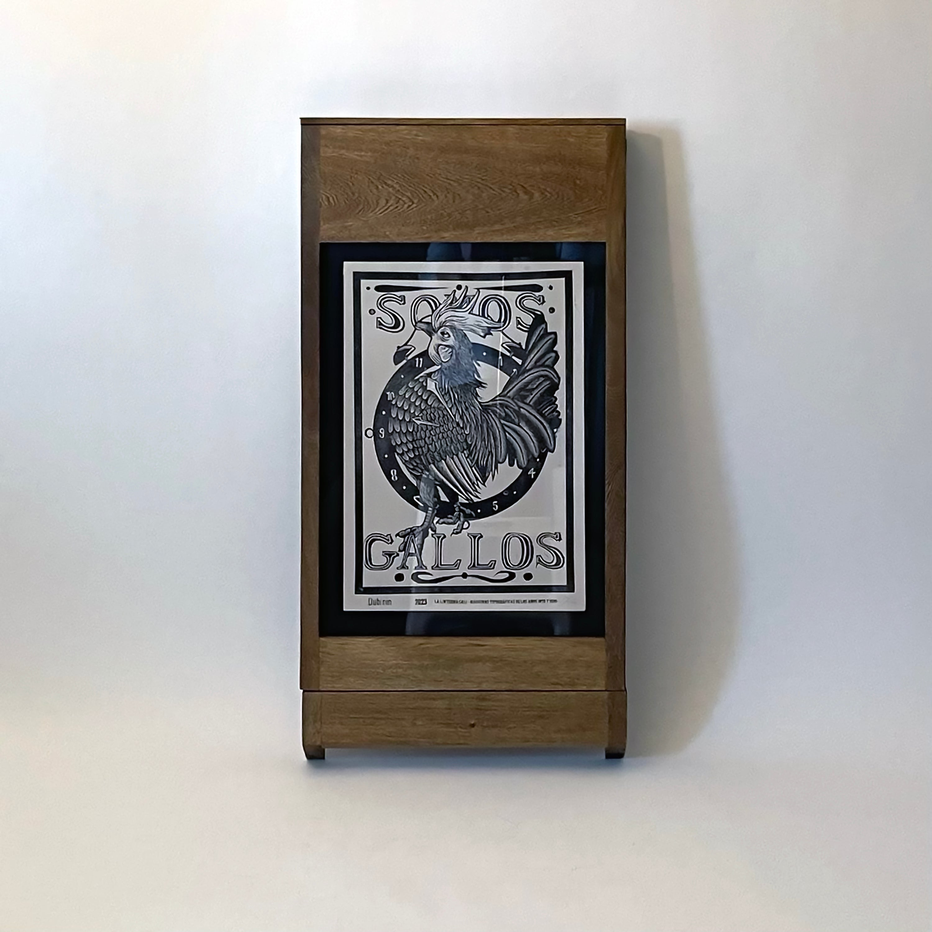 PicChair in dark oak; view of chair folded up as a frame with art on the wall.