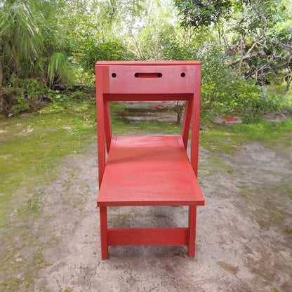 red PicChair open facing front, located in the woods