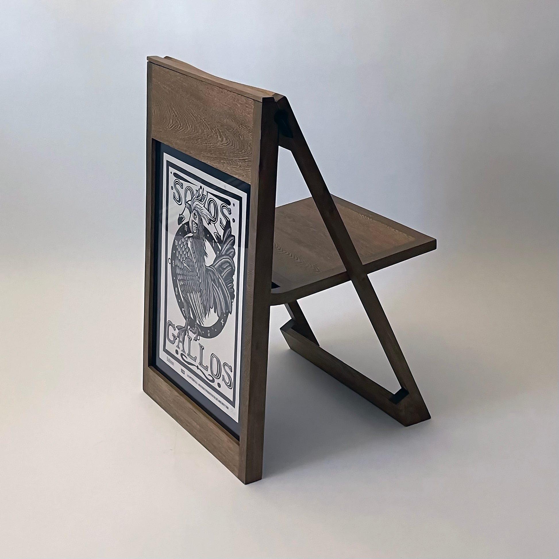 The PicChair in dark oak; Poster with a graphic illustration of a bird.